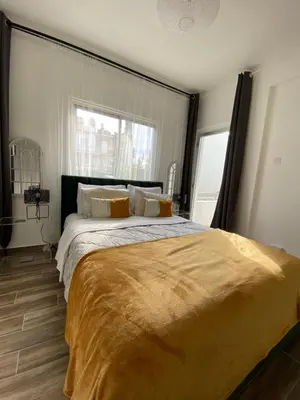 a large bed in a bedroom with a large window at Boho-Chic one bedroom flat in Engomi in Engomi