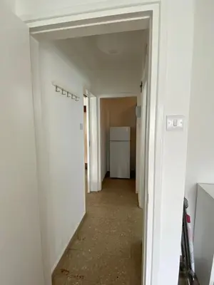 a hallway of an apartment with white walls and a white refrigerator at Boho-Chic one bedroom flat in Engomi in Engomi
