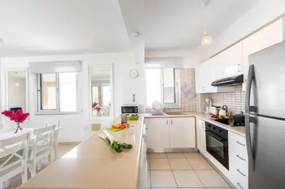 a kitchen with white cabinets and a counter top at Protaras Sapphire Seaside Villa in Protaras