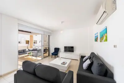 a living room with a black couch and a tv at Protaras Sapphire Seaside Villa in Protaras