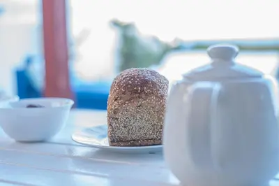 a piece of cake on a plate next to a bottle at Protaras Artisan Seafront Villa in Protaras