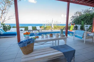 a table on a patio with a view of the ocean at Protaras Artisan Seafront Villa in Protaras