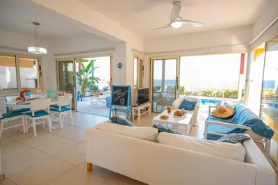a living room with a white couch and a table at Protaras Artisan Seafront Villa in Protaras