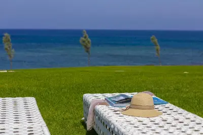 a hat sitting on a table next to the ocean at Beachfront Dream Villa in Protaras