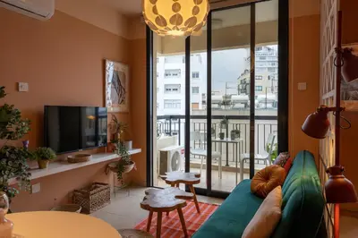 a living room with a blue couch and a large window at Johny's Spot in Larnaca in Larnaka