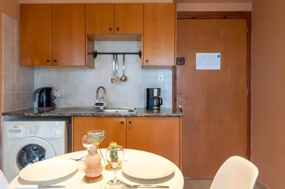 a kitchen with a table and a washer and dryer at Johny's Spot in Larnaca in Larnaka