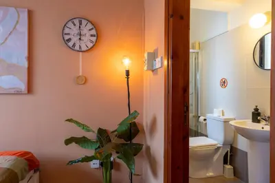 a bathroom with a clock on the wall and a plant at Johny's Spot in Larnaca in Larnaka