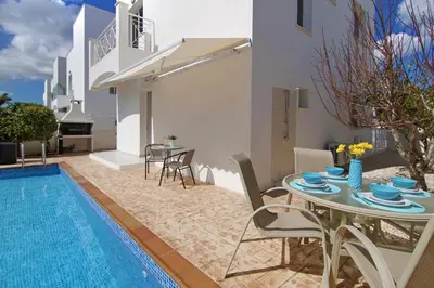 a villa with a pool and a table and chairs at Villa Nissinia - Nissi Beach Area in Ayia Napa