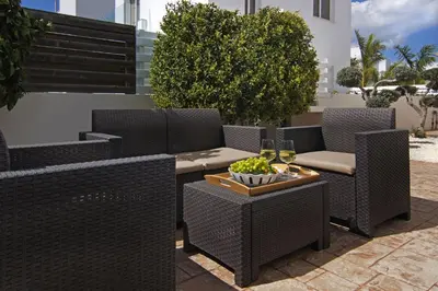 a patio with chairs and a table with a bowl of grapes at Villa Nissinia - Nissi Beach Area in Ayia Napa