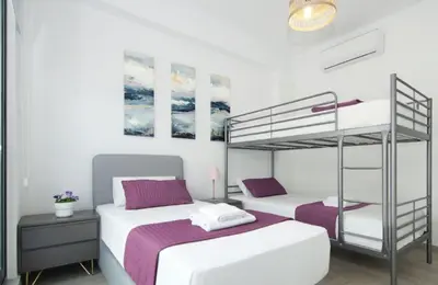 a bedroom with two beds and a bunk bed at Villa Nissinia - Nissi Beach Area in Ayia Napa
