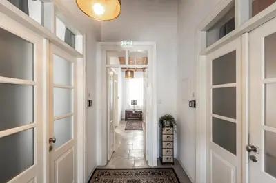 a hallway with white walls and doors and a rug at Edem Traditional House in Larnaka