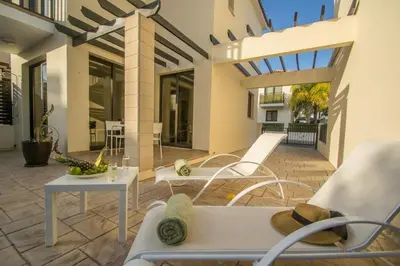 a patio with white chairs and a table on a patio at Protaras Allium Villa in Protaras