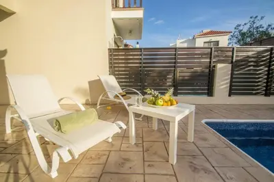 a white table and chairs sitting on a patio at Protaras Allium Villa in Protaras