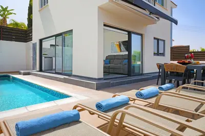 a villa with a swimming pool and patio furniture at Villa Royal View in Protaras