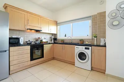 a kitchen with a washing machine and a window at Villa Royal View in Protaras