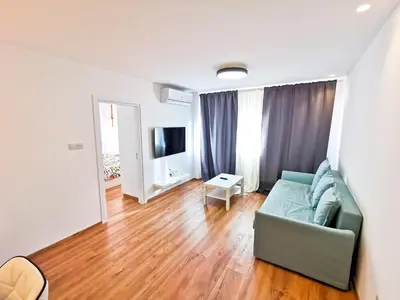 a living room with a couch and a television at CityCenter Boutique Apartment in Larnaka