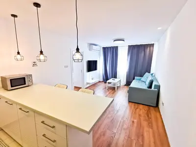 a kitchen and living room with a couch and a microwave at CityCenter Boutique Apartment in Larnaka