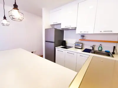a kitchen with white cabinets and a stainless steel refrigerator at CityCenter Boutique Apartment in Larnaka