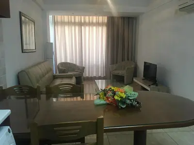 a living room with a table with flowers on it at Marina Apartments 211 in Larnaka