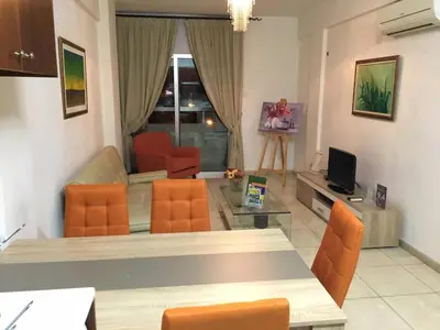 a living room with a table and orange chairs at Marina Apartments 211 in Larnaka
