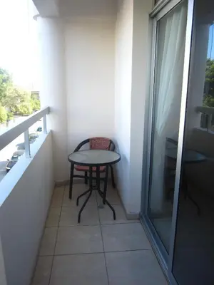 a small table and a chair in a small balcony at Marina Apartments 211 in Larnaka