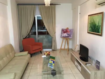 a living room with a couch and a chair and a television at Marina Apartments 211 in Larnaka