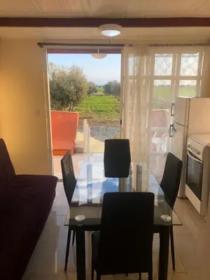 a dining room with a glass table and chairs at MERSINERA Paradise Garden NOAH HOUSE in Kivisil