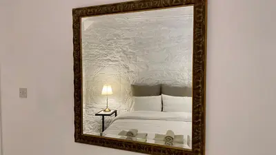 a mirror hanging on a wall with a bed at Leonys House by TrulyCyprus in Doros