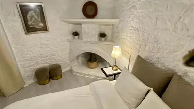 a white living room with a couch and a fireplace at Leonys House by TrulyCyprus in Doros