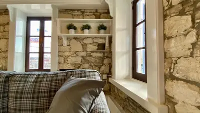 a living room with a couch and a stone wall at Leonys House by TrulyCyprus in Doros