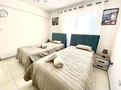 two beds in a bedroom with a window at NISSI 3 VIEW HOLIDAY 2 BEDROOM APARTMENT in Ayia Napa