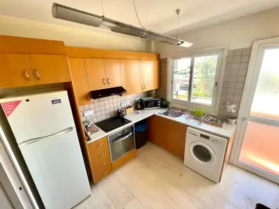 a kitchen with wooden cabinets and a white refrigerator at 3Bdr in Nicosia in Strovolos