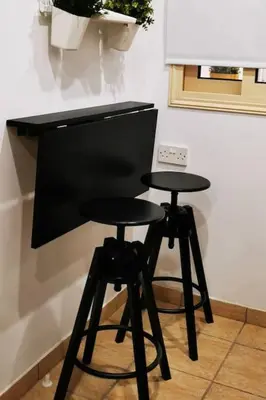 a black desk with two stools in a kitchen at Pretty and quiet studio, with wifi and parking in Limassol