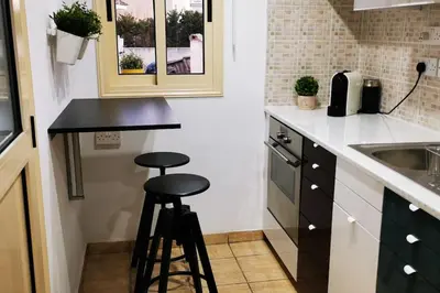a kitchen with a counter and two stools in it at Pretty and quiet studio, with wifi and parking in Limassol
