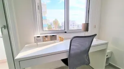a desk with a chair in front of a window at Spacious Lightflooded 2BR Apt / Near Center & Harbour in Larnaka
