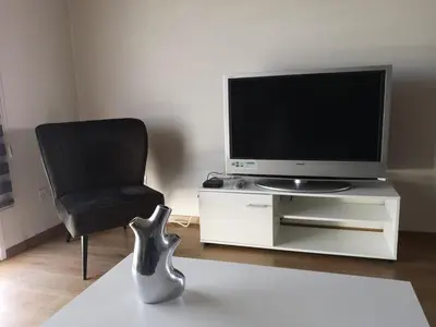 a living room with a chair and a television at KALIDONIA RESIDENCE Suite Nicosia , Spacious 2 BR suite with office in Nicosia
