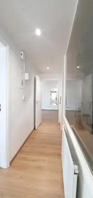 a hallway with white walls and a wooden floor at KALIDONIA RESIDENCE Suite Nicosia , Spacious 2 BR suite with office in Nicosia