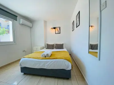 a bedroom with a bed with two towels on it at Serena's 2-BR Apartment in Larnaca in Larnaka