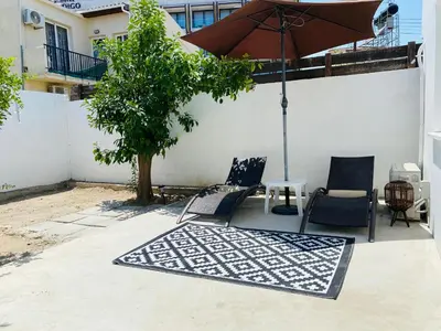 a patio with two chairs and an umbrella at Serena's 2-BR Apartment in Larnaca in Larnaka