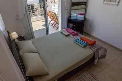 a bed with pillows on it in a room at Mythical Sands Resort & Spa, Evilion Apartment in Paralimni