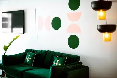 a green couch in a living room with a wall with green circles at New Leventis Luxury Κing Suite 41-Central Location in Ayia Napa