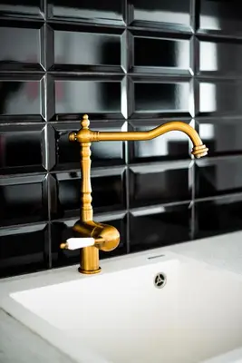 a sink with a gold faucet on top of it at New Leventis Luxury Κing Suite 41-Central Location in Ayia Napa