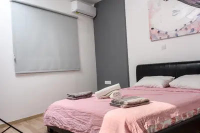 a bedroom with a bed with a pink blanket at Valdivian Flat 18 in Larnaka