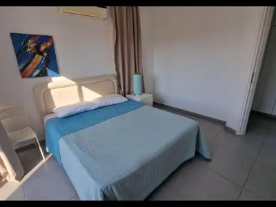 a bedroom with a bed with a blue blanket at Sunny holiday by konnos in Paralimni