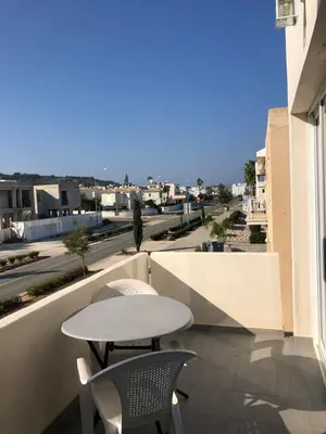 a table and chairs on a balcony with a view of a street at Sunny holiday by konnos in Paralimni