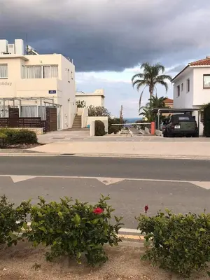 an empty street in front of a house with the ocean at Sunny holiday by konnos in Paralimni