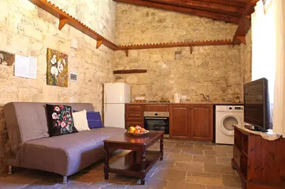 a living room with a couch and a tv at Agrovino Lofou in Lofou