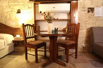 a wooden table and chairs in a room at Agrovino Lofou in Lofou