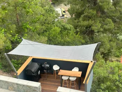 a tent on a deck with a table and stools at Nagia’s Apartment in Kakopetria