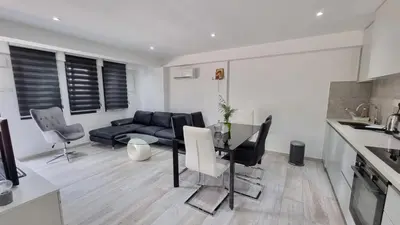 a kitchen and living room with a table and a couch at Nagia’s Apartment in Kakopetria